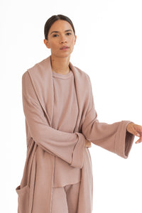 women wears a dusty pink waffle textured robe with matching pink waffle shirt and pants loungewear set  