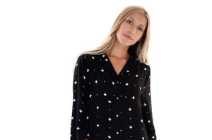 A blonde model in a black print V-neck sleep tee. Arms are mid-length and sleep tee is just above the knees.
